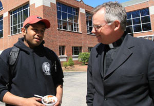 Rev John Denning, CSC, with a student at Stonehill College