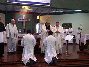 Bishop Izaguirre lays hands on Elmer and Julio in their Ordination
