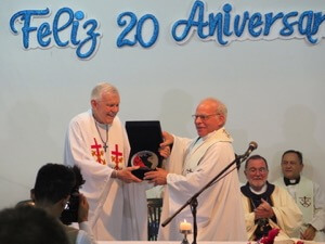 Fr Willy Raymond, CSC, presents an award to Fr David Farrell, CSC, for his leadership founding INFAM