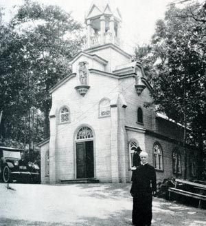 St Andre in front of the original Chapel to St Joseph