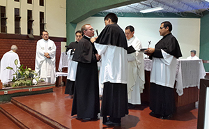 Fr David Olarte helps Sebastiao Correia with his cape