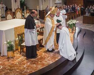 Bishop Rhoades lays hands on Pat Reidy in the Ordination Mass