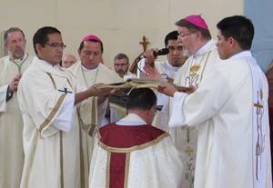 The Book of the Gospels is held over Bishop Colgan during the Rite of Ordination
