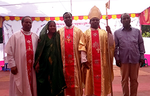 Fr Paschal Babu Sarkar, CSC, with his family and Fr James Cruze, CSC, and Bishop Sebastian Tudu
