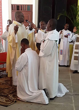 Fr Eric Jasmin, CSC, prays for the men professing Final Vows