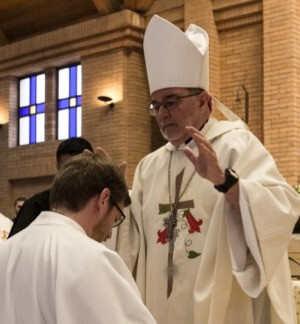 Bishop Colgan prepares to lay hands on Michael Thomas for his Deaconate Ordination