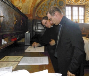 Bishop Nicolas Brouwet and Fr Romuald Fresnais, CSC, review papers of the new school
